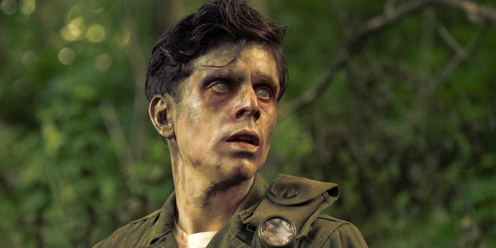 Rudy Mancuso as Captain Pauly Russo looking to the left in the woods with cloudy eyes in IT: Welcome to Derry