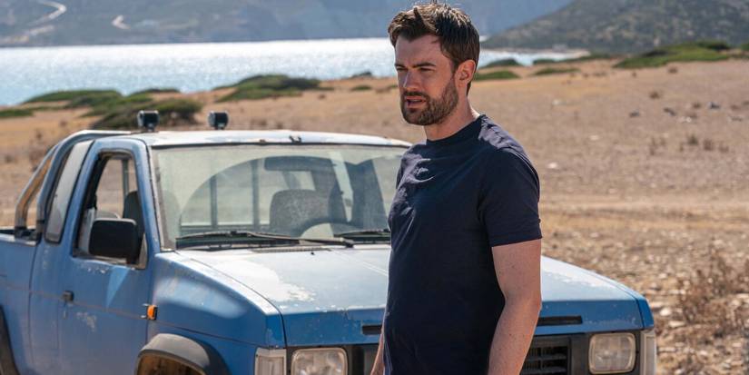 Jack Whitehall bleeding from his lip next to an old car in Malice 