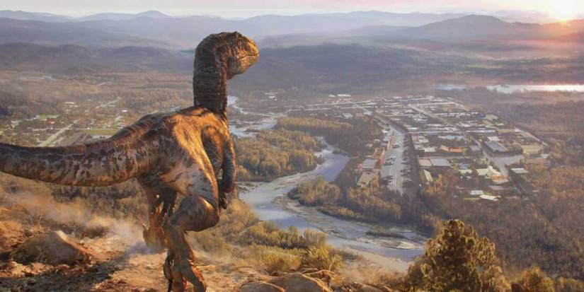 A velociraptor in a cliff looking to the distance in Jurassic World Dominion