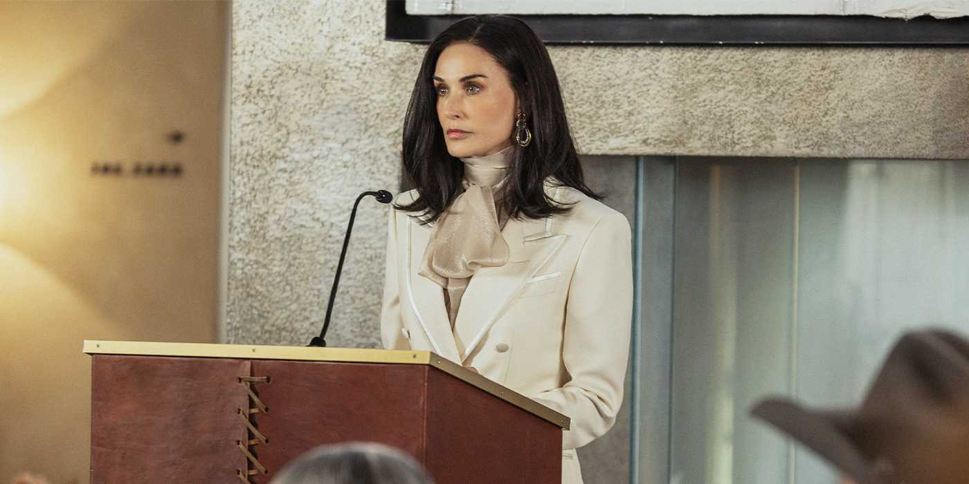 Cami Miller (Demi Moore) standing at a podium in a white suit in Landman Season 2.