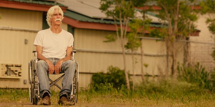 T.L. Norris (Sam Elliott) looks out over a field sitting in a wheelchair in Landman Season 2.