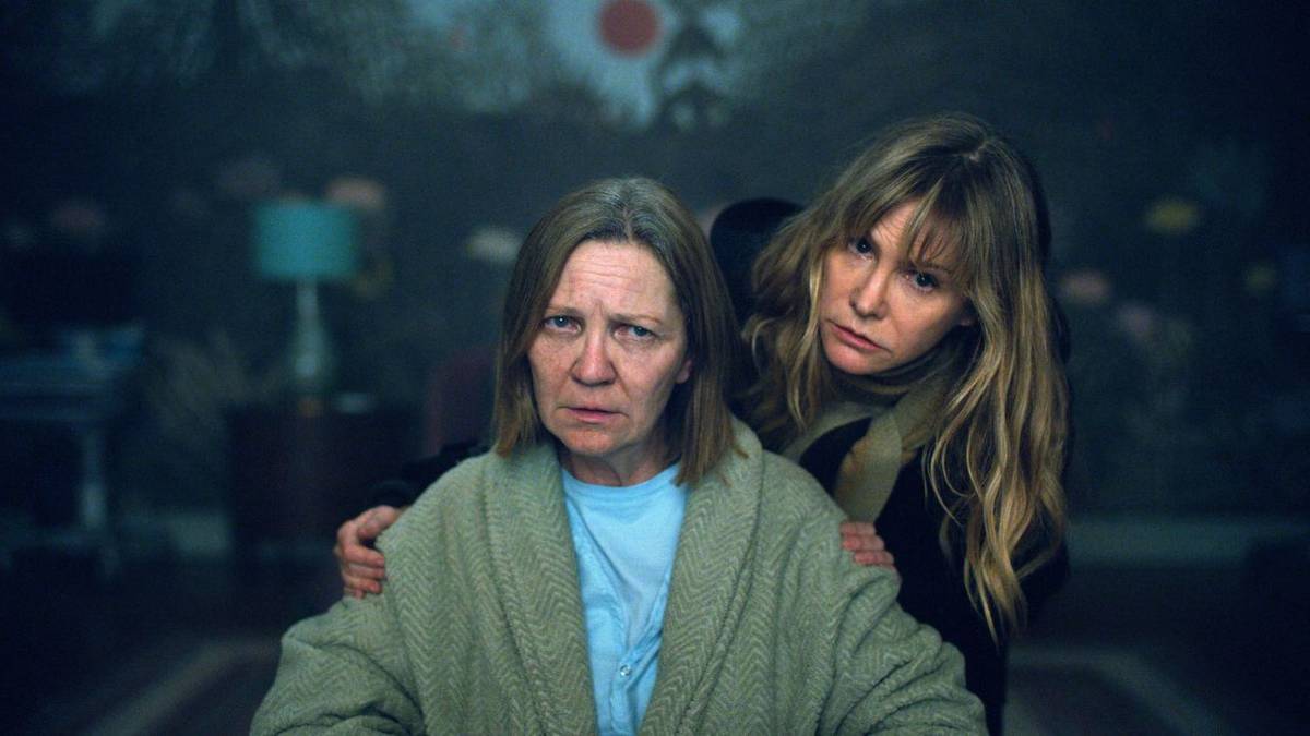 A woman looking over the shoulder of an older woman sitting down