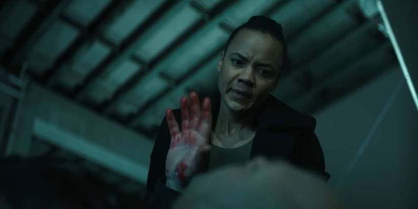 Frances Neagley (Maria Sten) watches Guy Russo (Domenick Lombardozzi) die in her arms in 'Reacher'.