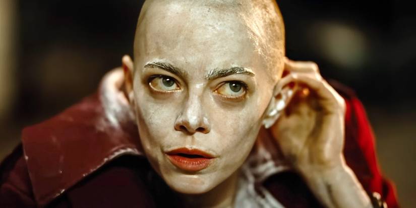 Emma Stone in Bugonia touching her bald head