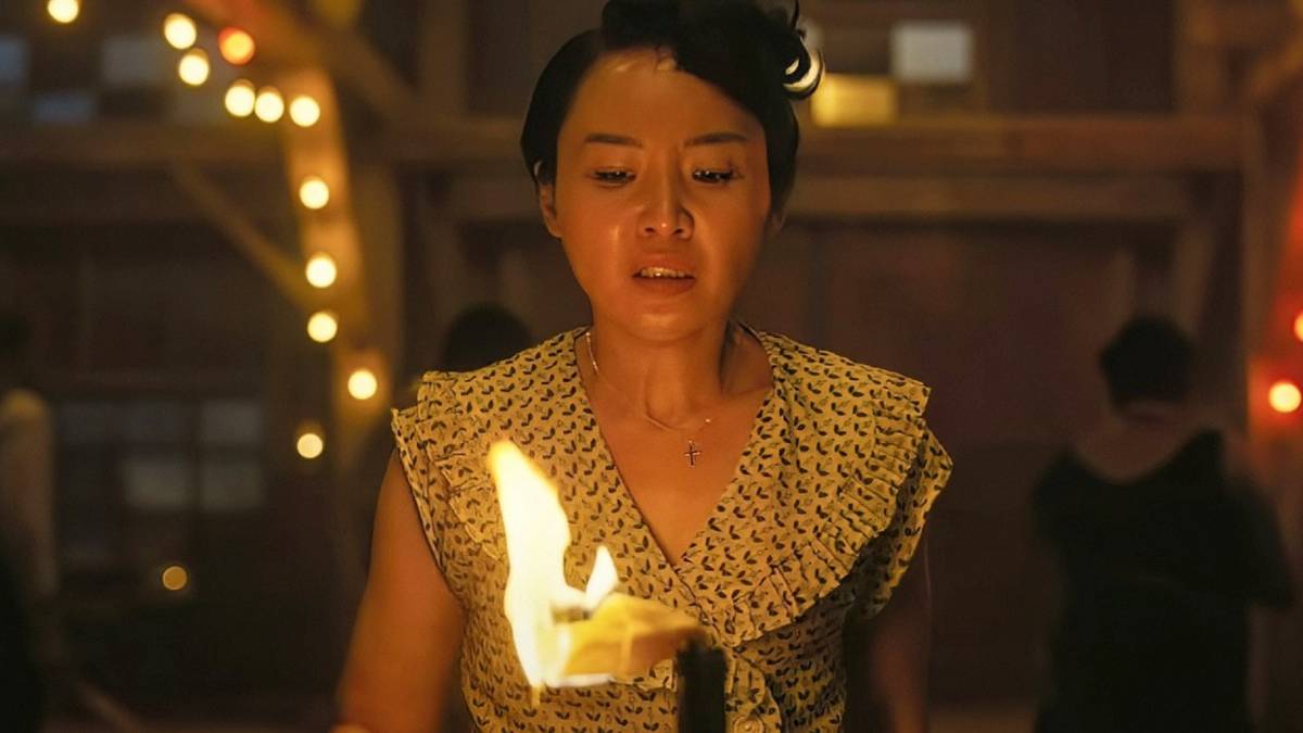 A woman looks down at a molitav cocktail in her hands in Sinners