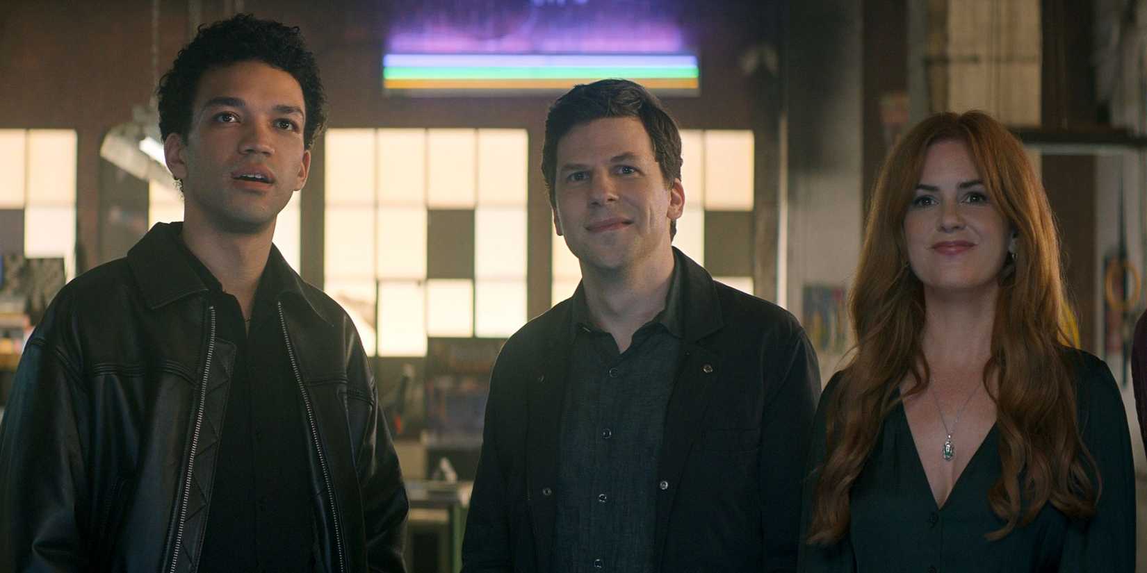 Justice Smith, Jesse Eisenberg, and Isla Fisher stand listening and happy in Now You See Me: Now You Don't.