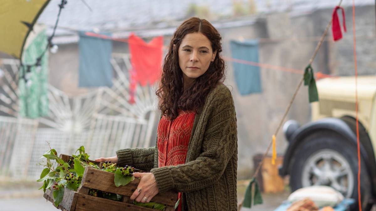 Elaine Cassidy carrying a carton of berries in Sanctuary: A Witch's Tale Season 2