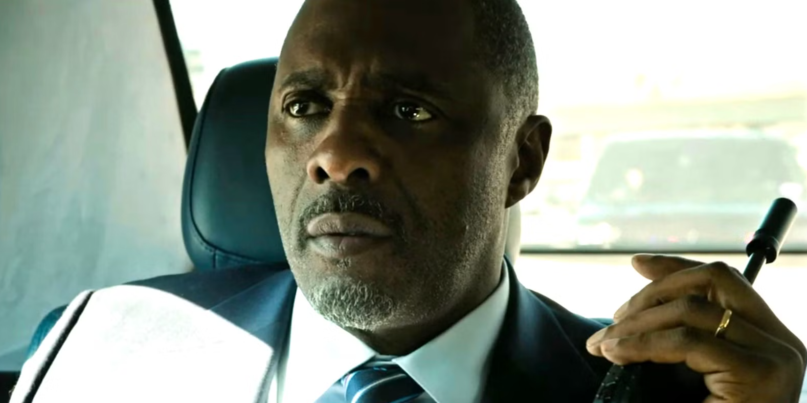 Idris Elba's President Holds a Radio while riding in the backseat in 'A House of Dynamite'
