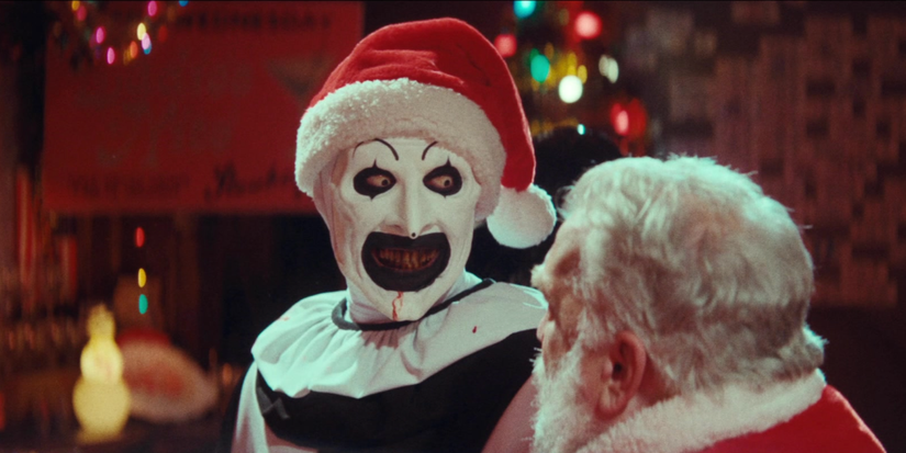 Art the Clown smiling while sitting on Santa's lap in 'Terrifier 3.'