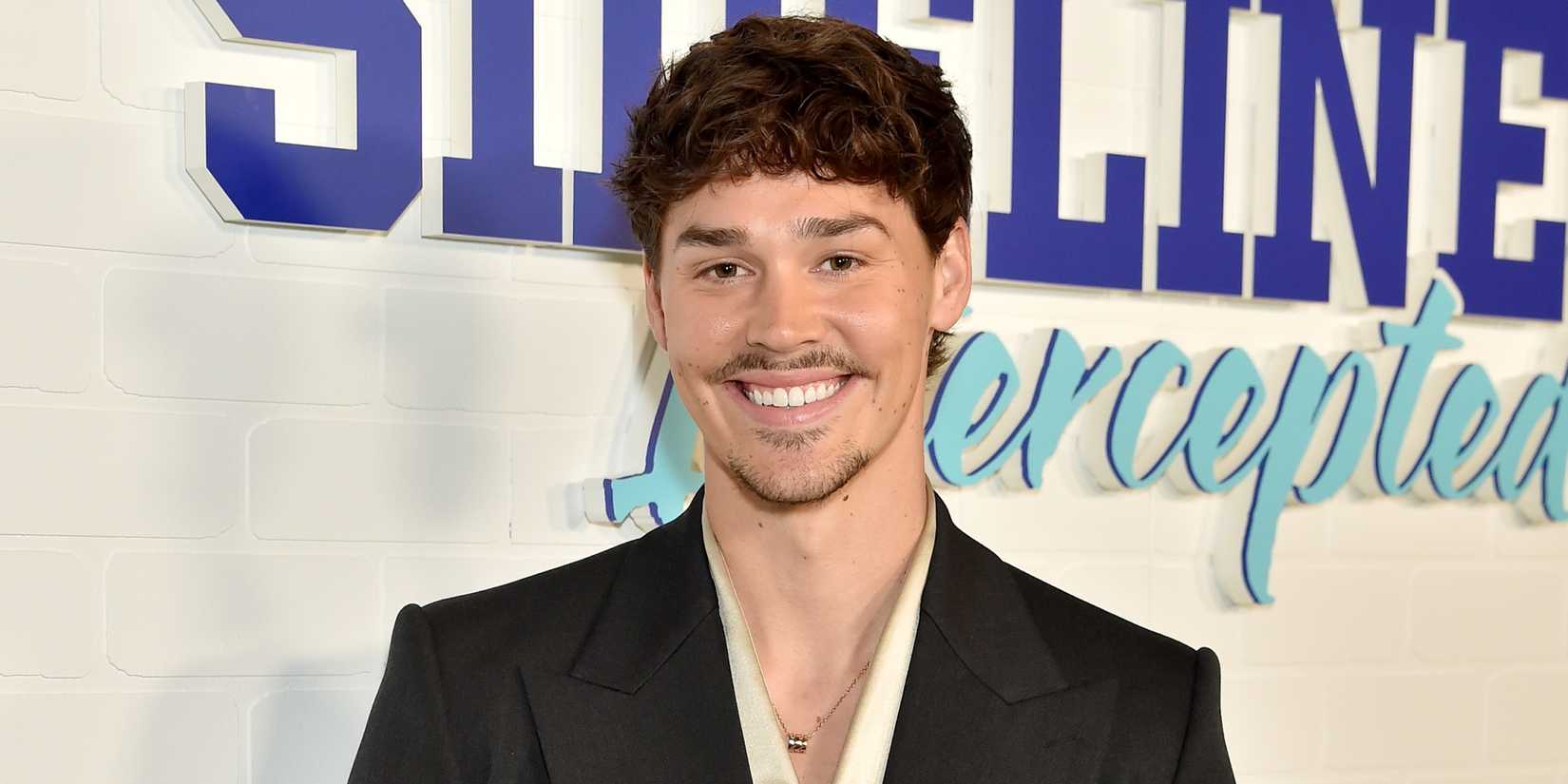 Noah Beck smiling on the red carpet at the Los Angeles premiere for Sidelined 2: Intercepted