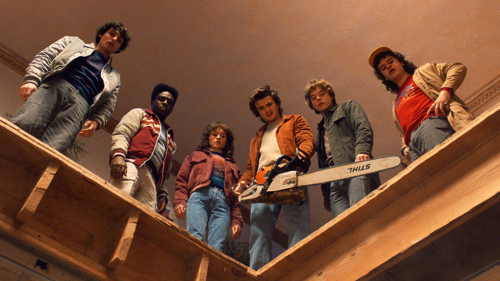 Hawkins' heroes in Stranger Things 5 looking down through a hole they cut in a floor.