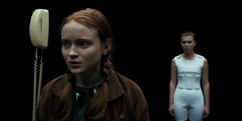 Max and Eleven standing in darkness in Stranger Things.