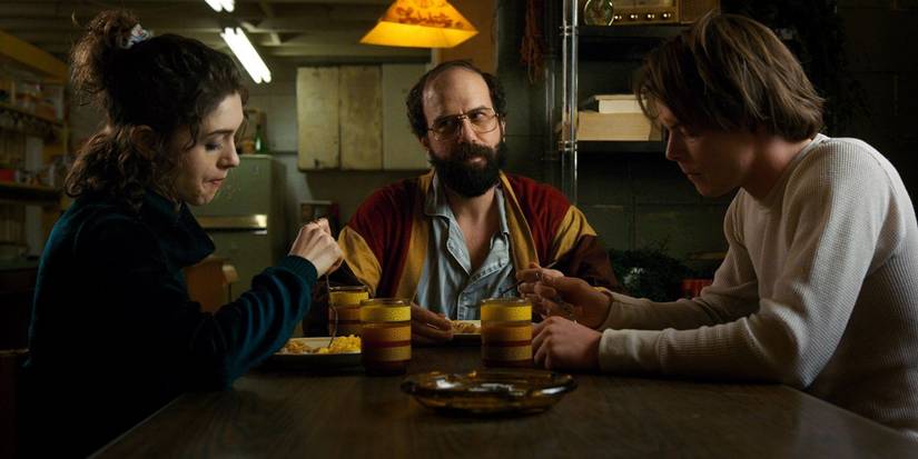 Nancy, Murray, and Jonathan sitting around a table in 'Stranger Things' Season 2.