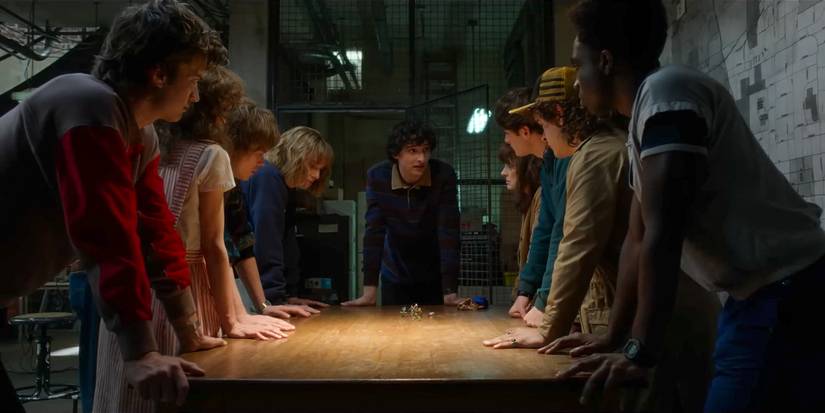 Stranger Things Season 5 Trailer still of main gang leaning on a table in WSQK plotting.
