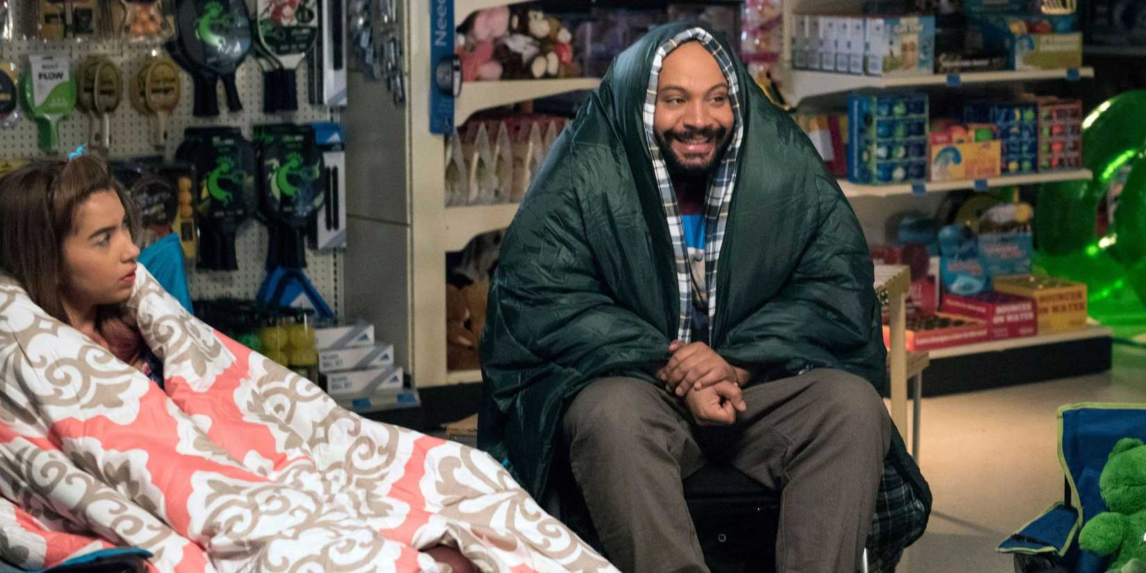 The employees wrap up in blankets in the store and chat in Superstore episode All-Nighter.