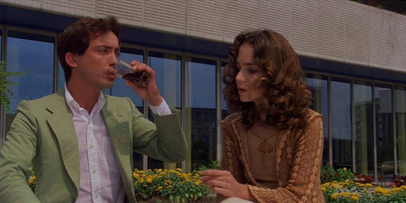 Udo Kier drinking next to a woman in Suspiria