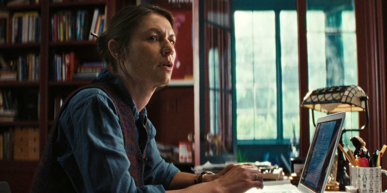 Claire Danes sebagai Aggie duduk di meja kantornya di depan laptopnya di The Beast in Me