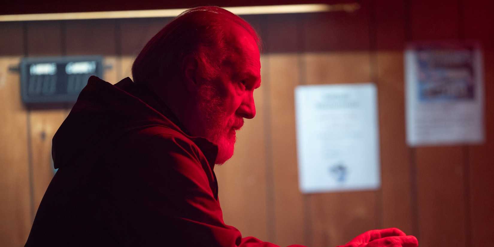 Tracy Letts as Frank Martin sitting in profile at a bar while bathed in red light in The Lowdown