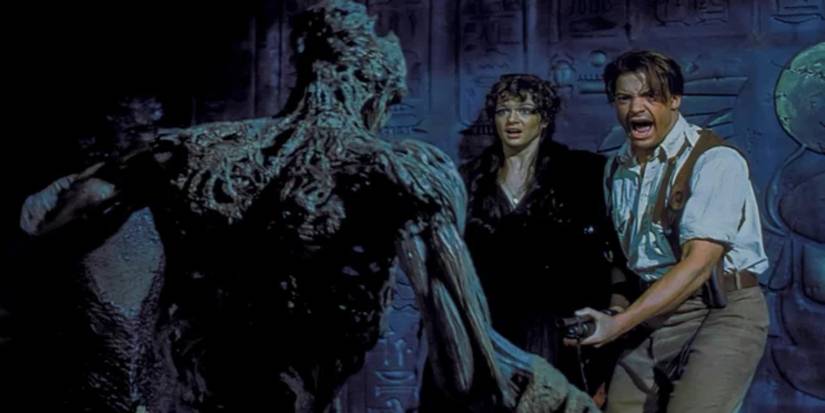 Image of Rick (Brendan Fraser) and Evelyn (Rachel Weisz) confronted by the Mummy Imhotep (Arnold Vosloo) in 'The Mummy' (1999).
