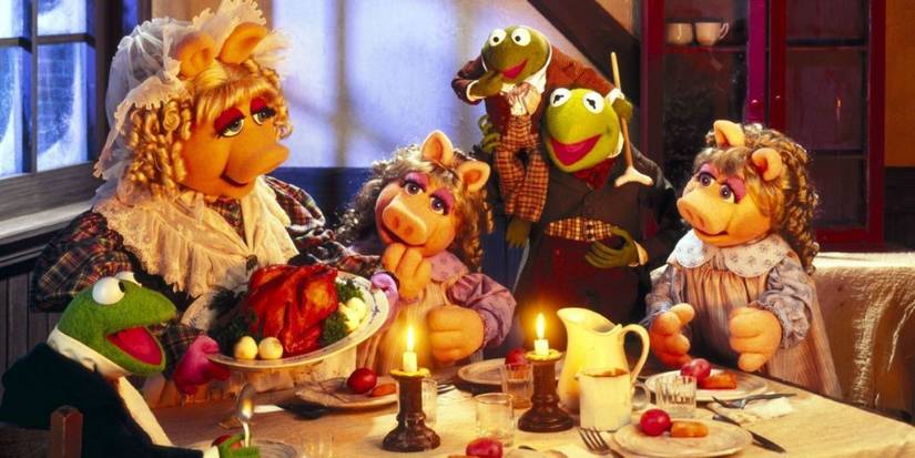 Miss Piggy, Kermit the Frog, and their kids eating dinner during The Muppet Christmas Carol.