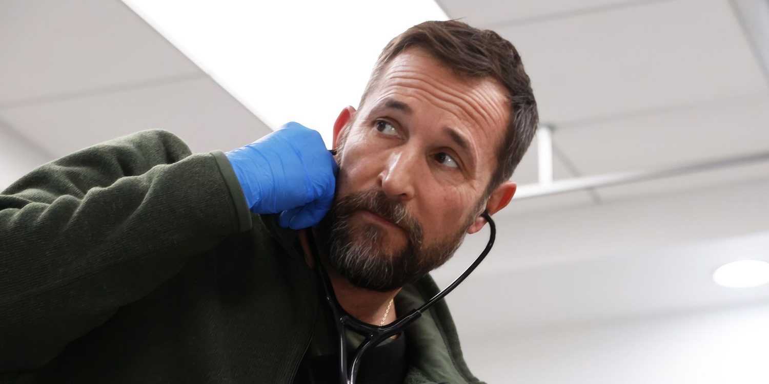 Noah Wyle listening to a stethoscope and looking to the side in The Pitt.