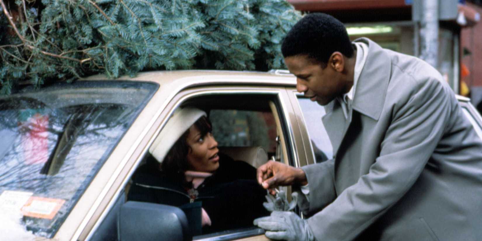 Denzel Washington talks to Whitney Houston who is in a car with a Christmas tree atop in The Preacher's Wife.