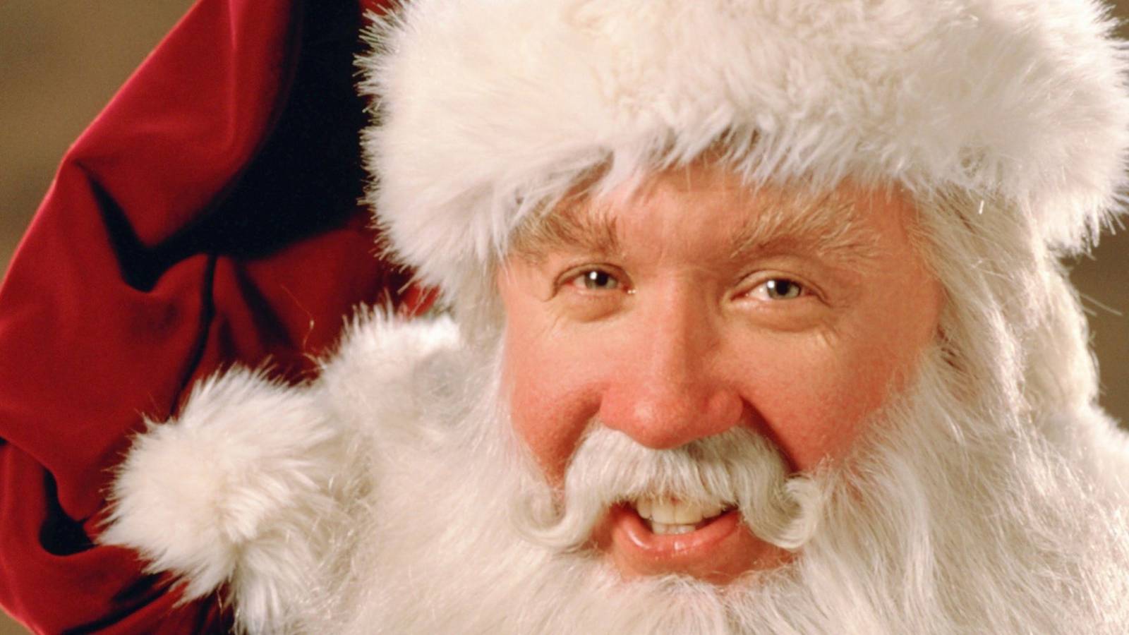 Tim Allen dressed as Santa and looking at the camera for The Santa Clause.
