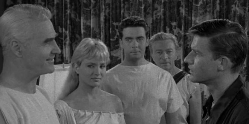 An astronaut talks to someone with others in white nearby in The Twilight Zone's People Are Alike All Over.