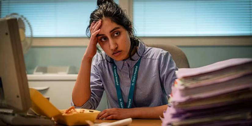 Shruti sits dejected at a desk in This Is Going To Hurt.