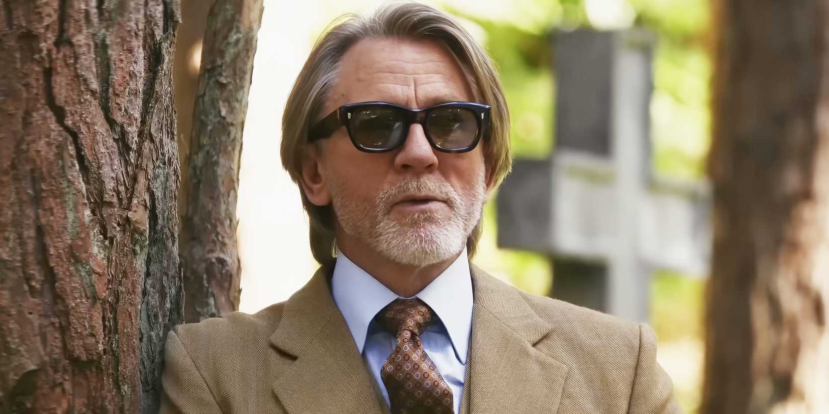 Benoit Blanc (Daniel Craig) leaning against a tree in Wake Up Dead Man