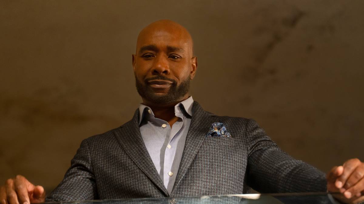 Morris Chestnut standing against a railing and looking down in Watson Season 2, Episode 8