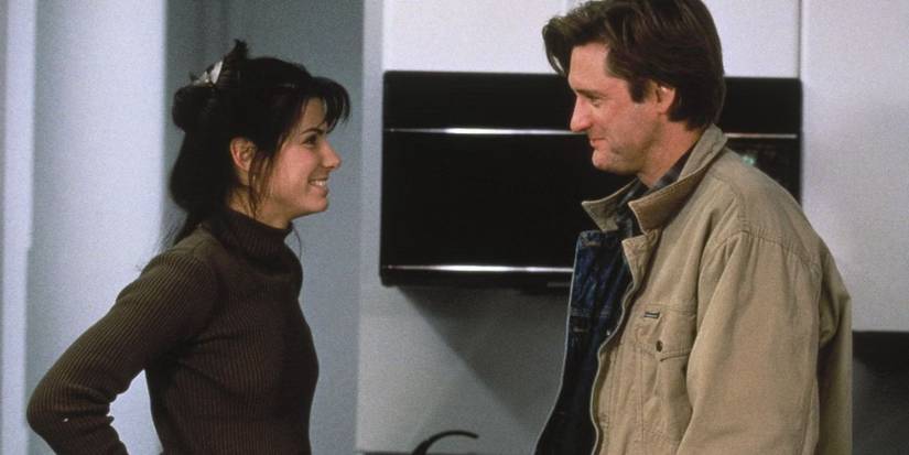 Sandra Bullock and Bill Pullman smiling at each other in 'While You Were Sleeping'