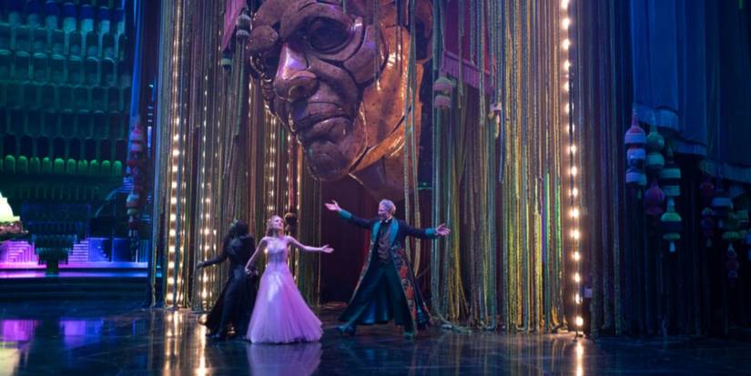 Elphaba, Glinda, and the Wizard dance beneath a mechanical wizard head in "Wonderful" in Wicked: For Good.