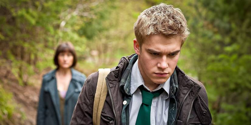Rhydian in the forest looking somber in Wolfblood.