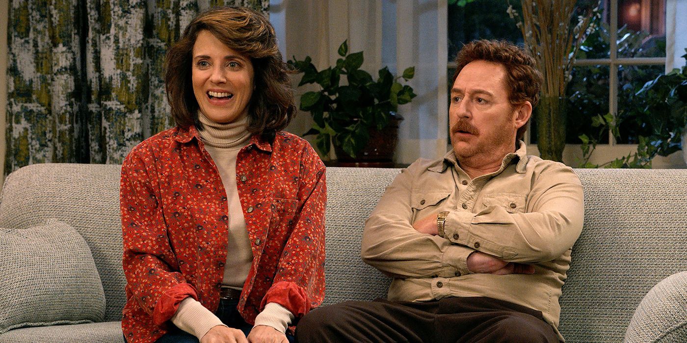Alanna Ubach and Scott Grimes chatting on the counch in Ted