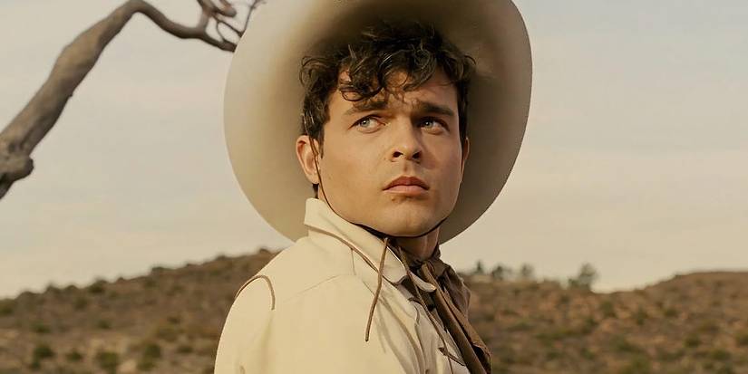 Alden-Ehrenreich dressed as a cowboy looking to the distance in Hail-Caesar