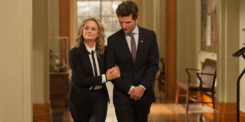 Adam Scott and Amy Poehler walk arm in arm down a quiet hallway on the Parks and Recreation series finale.