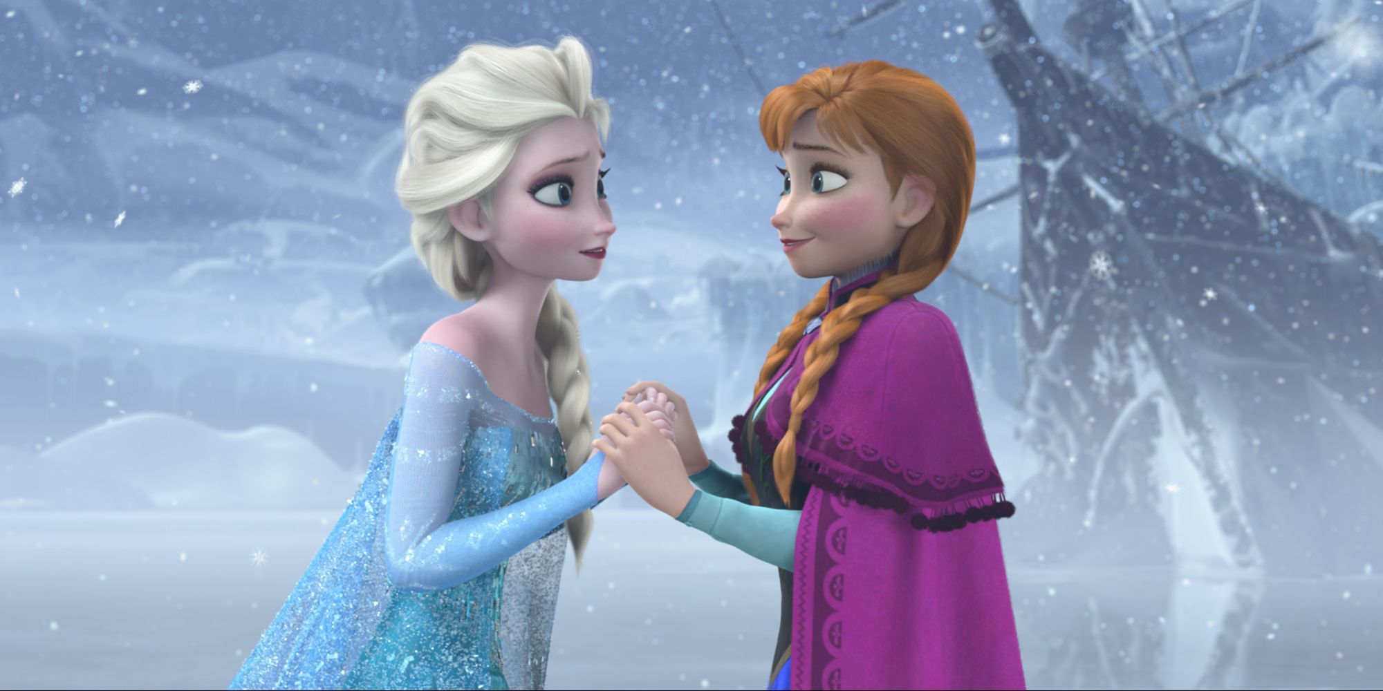 Anna and Elsa hold hands and smile at each other, standing on a frozen lake in Frozen.