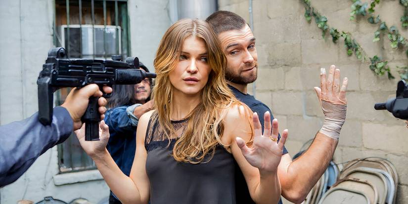 Ivana Milicevic as Carrie Hopewell  and Antony Starr as Lucas Hood standing back-to-back with their hands raised in the series Banshee.