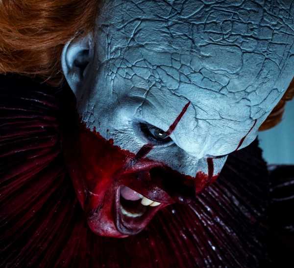 Bill Skarsgard as Pennywise yelling while half covered in blood in IT: Welcome to Derry.