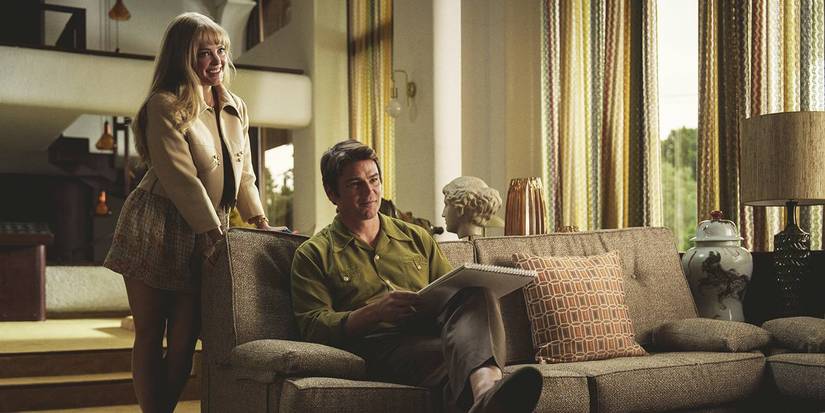 Jessica standing and leaning on the couch behind David in Black Mirror's Beyond the Sea