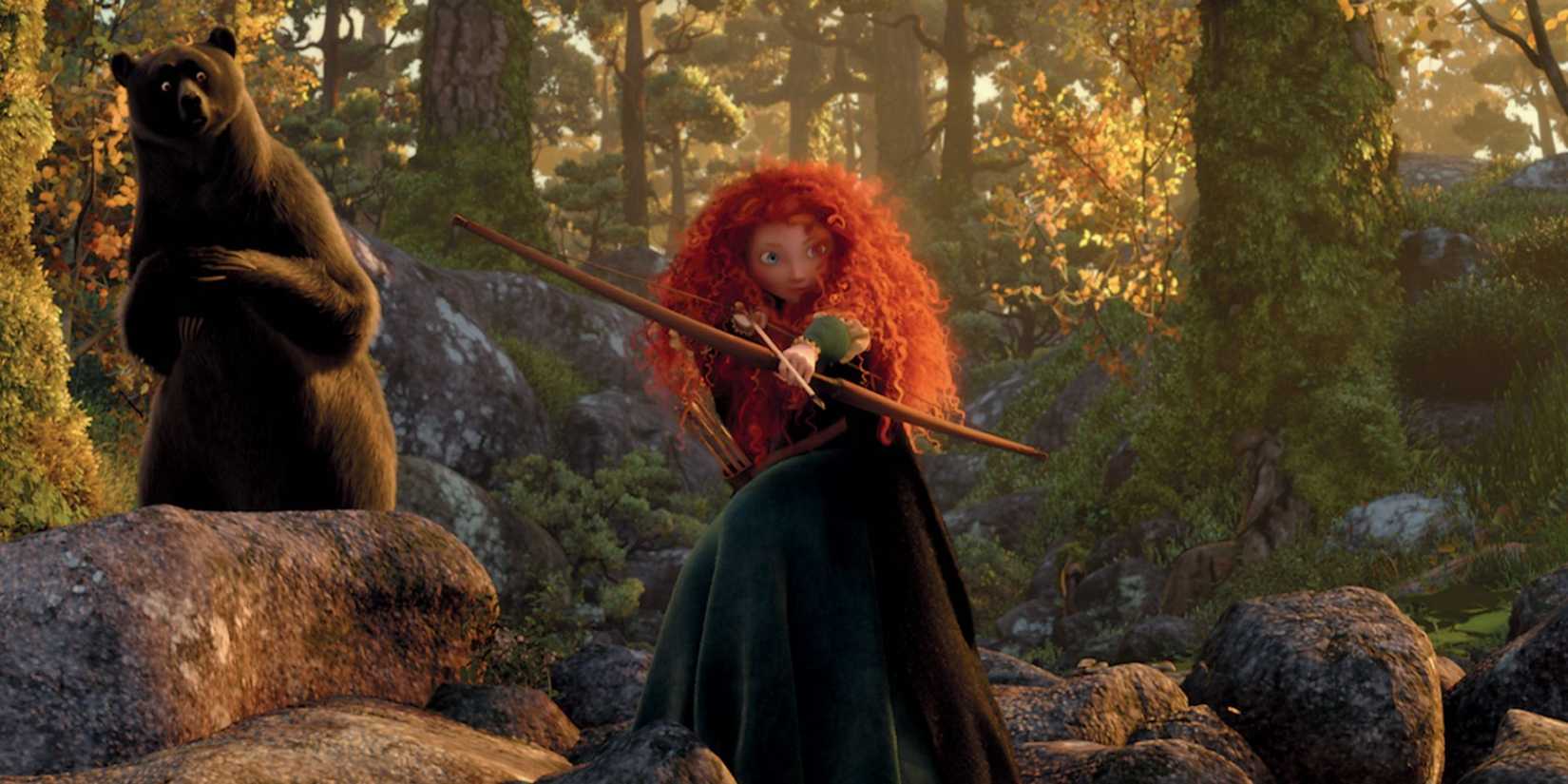 Merida draws a bow and arrow, about to take aim, standing on rocks with a bear behind in Brave.