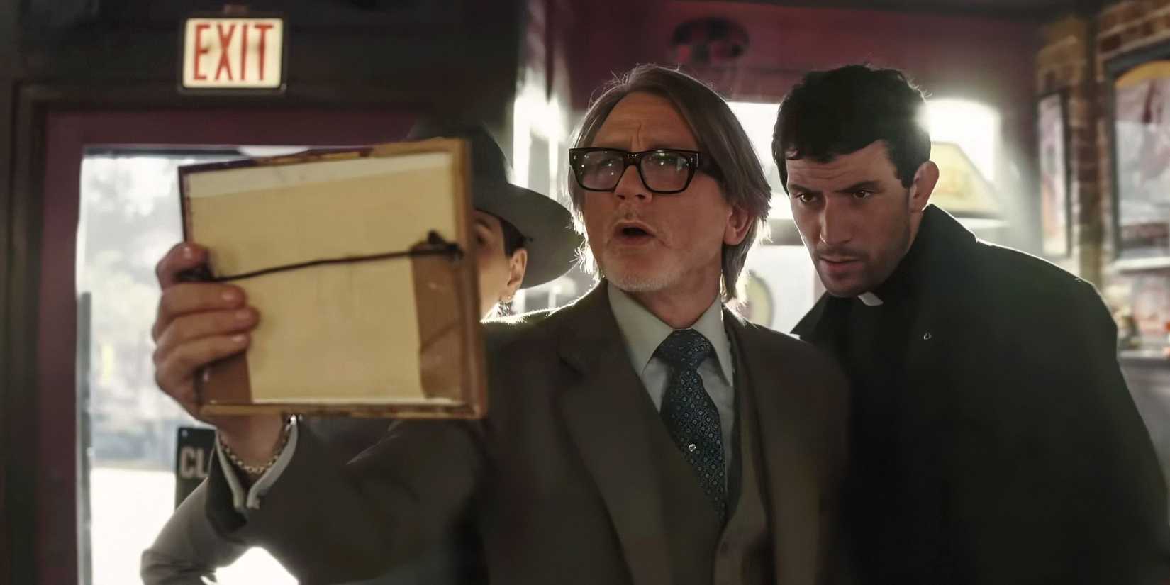 Mila Kunis, Daniel Craig, and Josh O'Connor look at a framed photo in a bar in Wake Up Dead Man