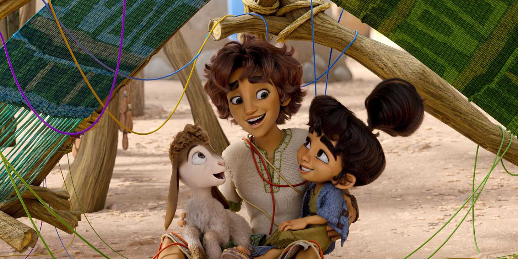 David holds his young sister and a small goat and they smile as they are entwined in yarn in the movie David