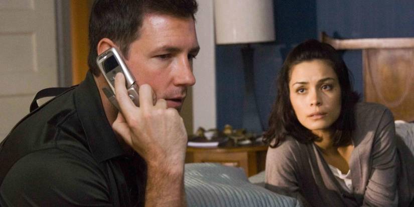 Detective Jack Andrews (Ed Burns) listens to the phone while Beth Raymond (Shannyn Sossamon) looks on in One Missed Call (2008).