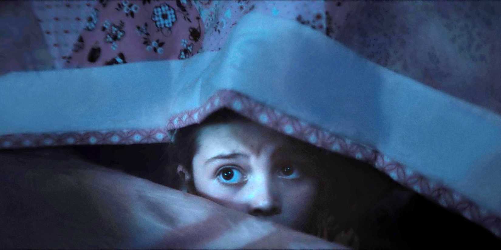 Sophia Sloan as Aurora hiding under the covers on her bed in Dust Bunny