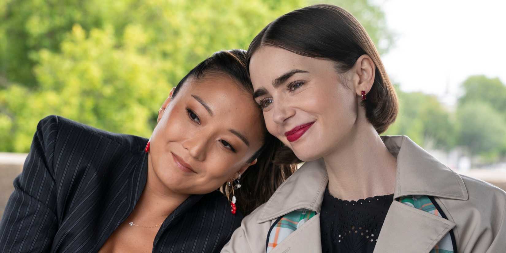 Lily Collins as Emily with Ashley Park as Mindy as they lean their heads together in Emily in Paris Season 5.