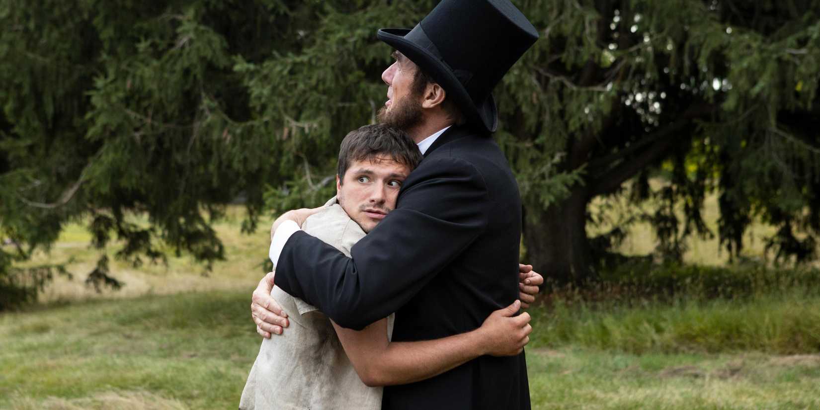 Josh Hutcherson looking confused and scared as he's hugged by Abraham Lincoln in Future Man