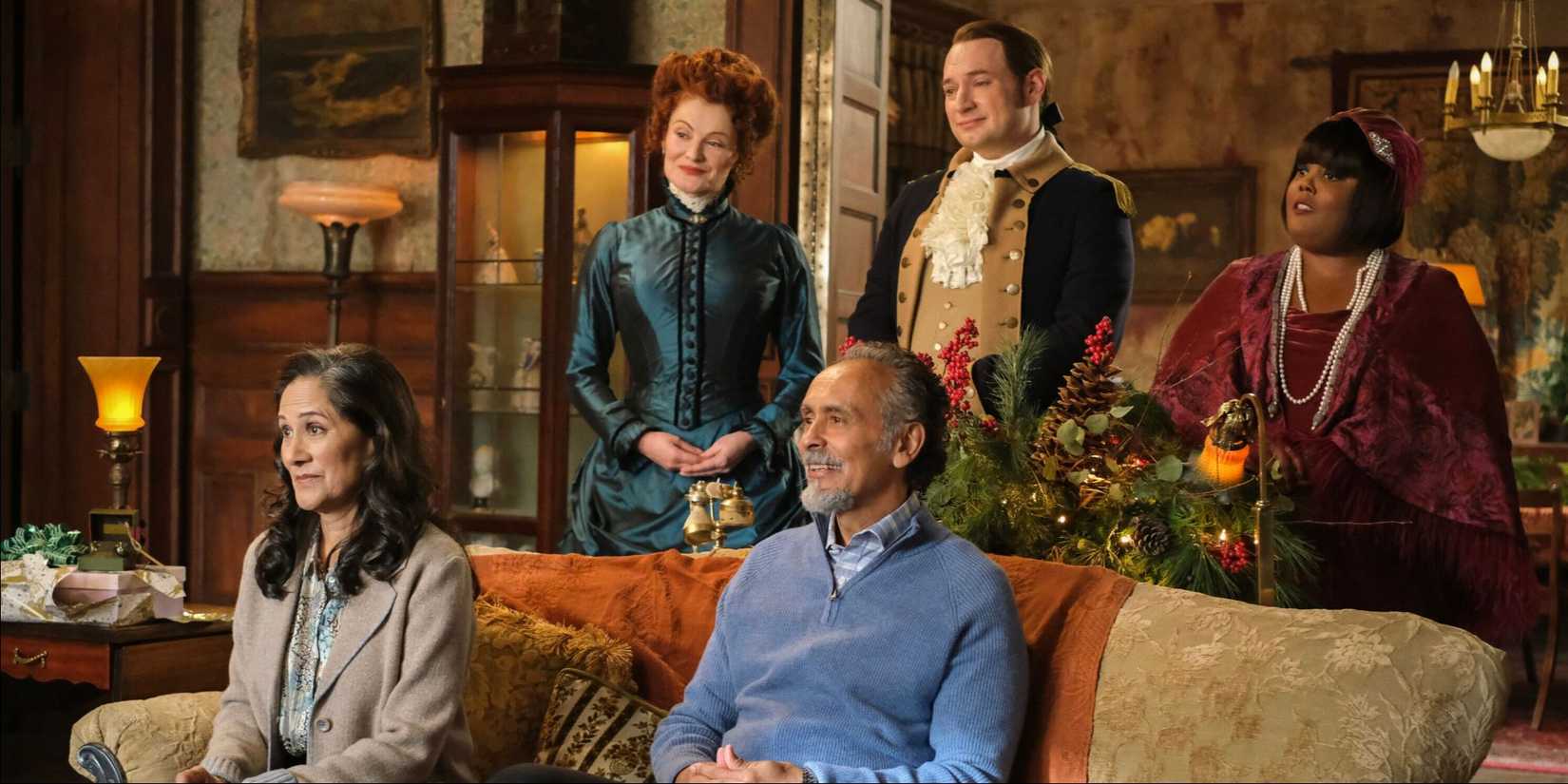 The cast gather in the home with Christmas decorations and look in the same direction in Ghosts. 