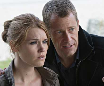 Colin Ferguson pointing ahead next to Emily Rose in Haven